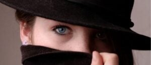 woman wearing black hat with face covered.