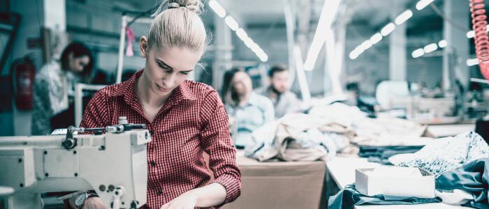 Woman in busy apparel factory